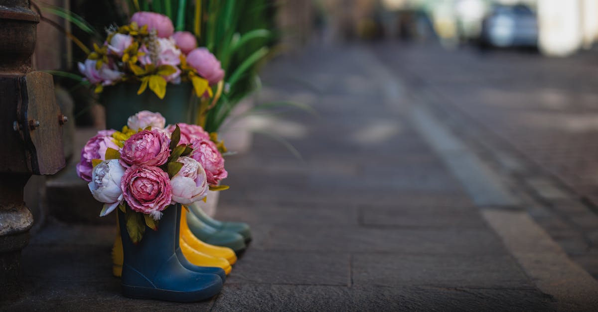 Vibrant spring flowers arranged creatively inside colorful boots on a city street.